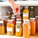 Organized spice jars in cabinet showing proper storage and labeling system