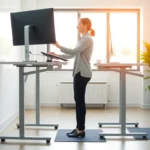 Person using adjustable standing desk with proper ergonomic setup