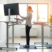 Person using adjustable standing desk with proper ergonomic setup