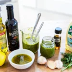 Fresh homemade salad dressing in glass jar with olive oil and herbs
